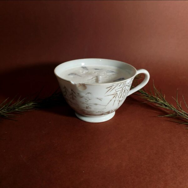 Bougie artisanale dans une tasse en porcelaine avec cire de soja et petite fleurs bleues séchées